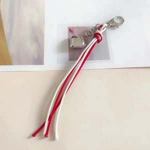 Handmade red and white woven cord keychain with a polished silver heart pendant and lobster clasp