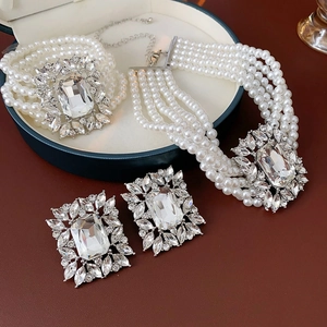 Close-up of luxury pearl jewelry set with diamond accents on a brown display box