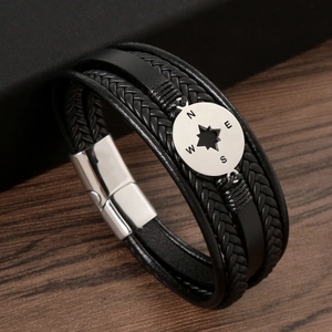 Detail of men's black braided leather bracelet with stainless steel compass magnetic clasp