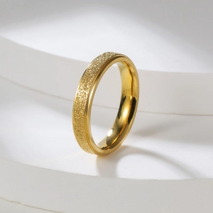 Detail of 2mm matte gold stainless steel ring featuring a sandblasted finish on textured surface