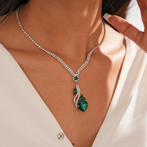 Gros plan du pendentif cœur en pierre verte avec accents de diamant sur chaîne argentée