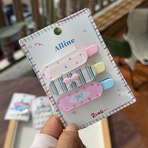 Trois barrettes en acrylique colorées avec pois roses, rayures bleues et motifs fleuris
