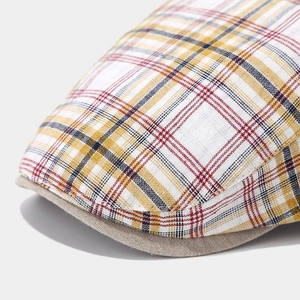 Close-up of vintage plaid beret fabric texture and contrasting canvas brim detail