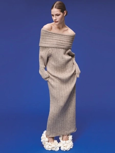 Close-up of beige off-shoulder knitted maxi dress with vertical ribbed texture and slim fit