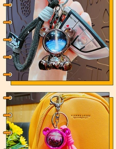 Detail of space bear keychain with Boom text and starry visor on woven strap