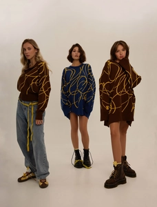 Detail view of oversized knitted sweaters with abstract yellow lines in brown and blue