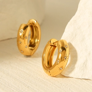 Detailed macro view of 18K gold-plated hoop earrings featuring zircon-set star engravings