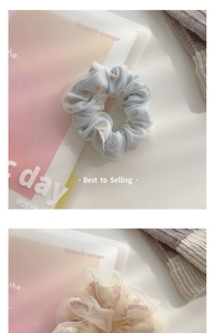 Detail of light blue daisy and pink floral scrunchies in soft mesh fabric