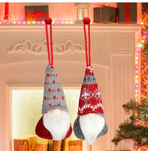 Detail of two Christmas gnome ornaments with knitted hats in grey and red patterns