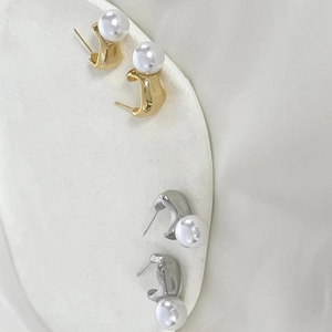 Clous d'oreilles élégants en perles et métal irrégulier fini or et argent sur plat