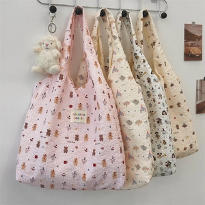 Detail of cute bubble fabric tote bag featuring cartoon animal prints and plush charm