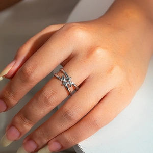 Macro shot of a silver knotted double-band ring showcasing textured cross-weaving details