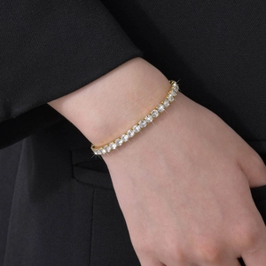 Close-up of sparkling gold cubic zirconia tennis bracelet worn on a female wrist