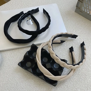 Detail of woven twist headbands in black and beige with anti-slip inner teeth design