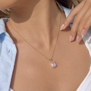 Elegant gold titanium steel necklace with a rectangular pink zircon pendant on a model