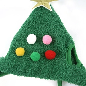 Macro detail of green Christmas tree pet hat showing fuzzy texture and colorful pom-poms