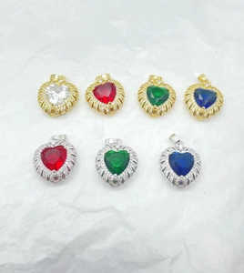Macro view of gold and silver heart pendants with colorful zircon gemstones and small diamonds