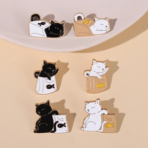 Close-up of black and white cartoon cat enamel pins in various playful poses