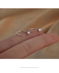 Close-up of minimalist silver spiral hook earrings featuring sparkling micro-set zircons