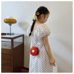 Toddler girl wearing a red flower shaped crossbody bag with metallic chain strap