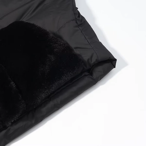 Close-up of black fuzzy fur patchwork on smooth fabric of casual winter jacket