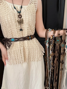 Close-up of bohemian brown woven waist chain with butterfly pendant and turquoise beads
