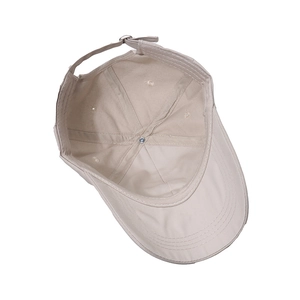 Detail of adjustable metal buckle and inner stitching on beige baseball cap