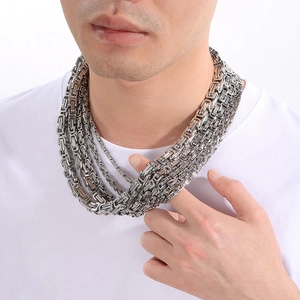 Gros plan d'un collier de chaîne byzantine en acier inoxydable poli porté par un mannequin
