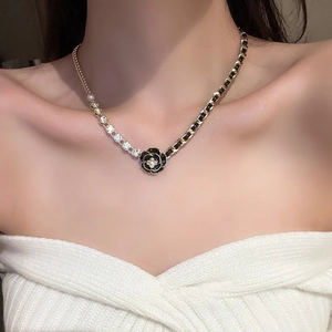 Detail of dark bow flower faux leather wrap necklace with pearl camellia pendant
