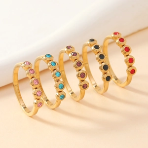 Detail showing five gold stainless steel rings set with colorful round gemstones