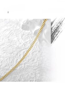 Artistic close-up of a gold Cuban link chain necklace draped on a white plaster sculpture