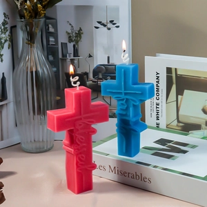 Detail of cross-shaped candles with faith and blessed relief text in a cozy home setting