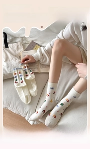 Détail de chaussettes en coton crème avec motifs de dessins animés et texture tricotée