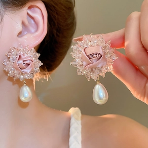 Close-up of pink fabric rose earrings with crystal beads and a pearl drop pendant