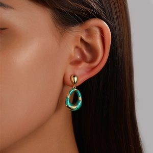 Teal enamel oval drop earrings in gold twisted metal finish shown on model's ear