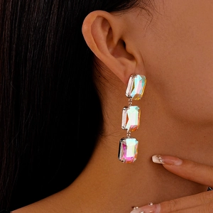 Close-up of model wearing luxury crystal square fringe earrings with rainbow gradient