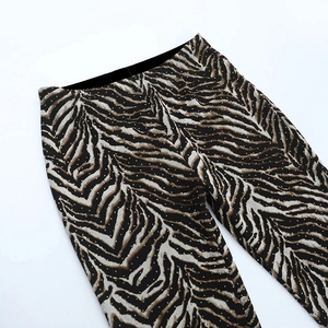 Detailed view of leopard print trousers with shimmering rhinestones and soft fabric texture