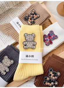 Macro shot of cotton crew socks featuring sparkling rhinestone bear patch decorations
