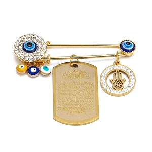 Detailed close-up of Evil Eye and Hamsa Hand charms on a gold safety pin brooch