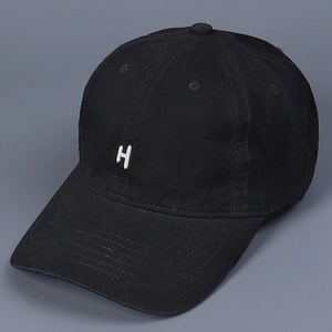 Detail of 3D white H letter embroidery on washed black cotton baseball cap