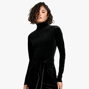 Detailed close-up of a black velvet long sleeve dress featuring an elegant waist knot detail