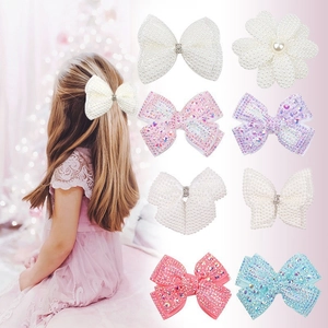 Detailed view of colorful bow hair clips set with pearls and rhinestones for girls