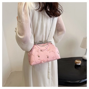 Detailed embroidery floral pattern on pink chain bag shown with a silver metal clasp