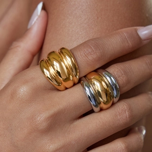 Macro shot of two-tone gold and silver chubby ribbed rings on model's hand