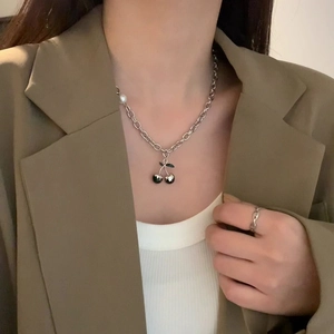 Hip hop pearl chain necklace with black cherry pendant on a model in a brown blazer
