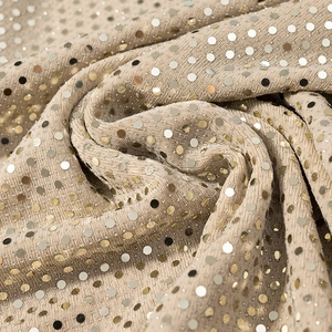 Dettaglio del tessuto di paillettes oro champagne con texture luccicante