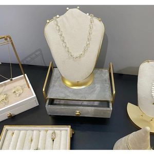 Macro shot of grey velvet and gold metal jewelry display stand for necklaces and rings