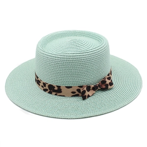 Detail of mint green straw boater hat featuring a leopard print ribbon and bow knot