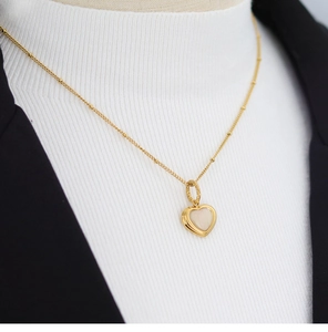 Detail of gold heart pendant with mother of pearl on a chic beaded necklace chain