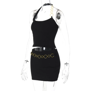 Détail de l'ensemble jupe noire avec chaînes dorées et anneaux métalliques à la taille
